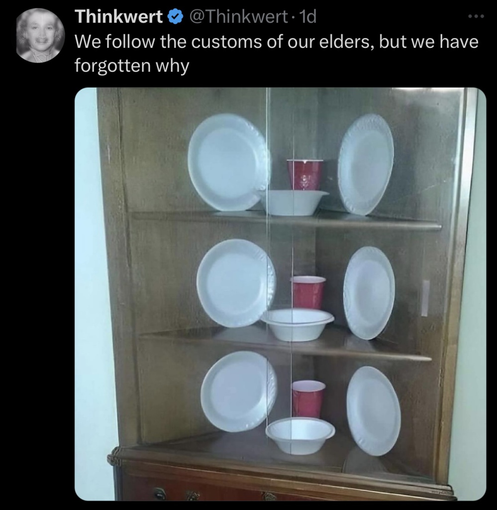 A display cabinet filled with disposable plastic and paper plates, bowls, and red plastic cups.
